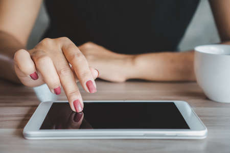 closeup woman hand using tablet, smart phone connecting to internetの写真素材