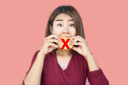 stop eating junk food concept with Asian woman over eating hamburgerの写真素材