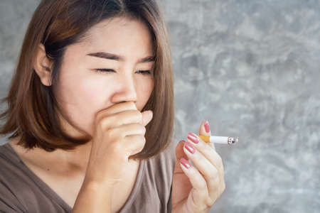 closeup Asian woman coughing from smoking cigaretteの写真素材