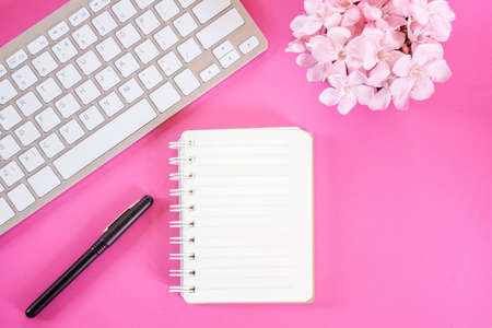 flower ,keyboard,pen and notepad flat lay pink on pink backgroundの写真素材