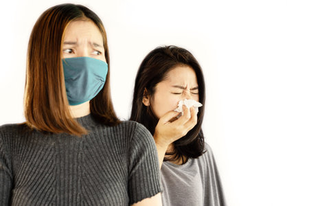 Asian woman wearing mask afraid of friend who having virus infection and coughing