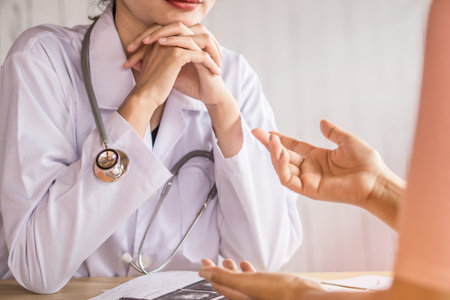 female doctor listening to depressed patient talking about health problem at a hospitalの写真素材