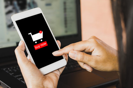 woman hand using smart phone and laptop shopping online from home on internet