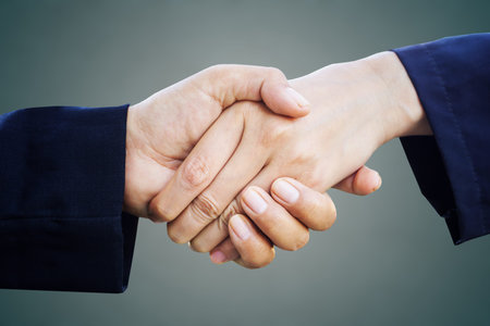two businessman handshake over grey background, partnership and success concept