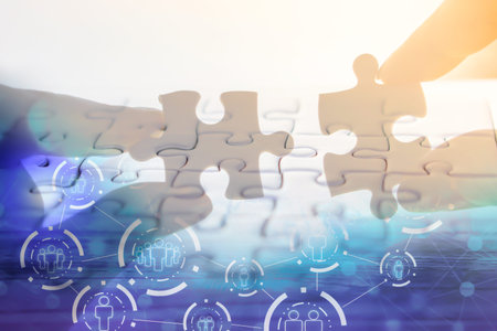 hand holding jigsaw piece with background of teamwork people connection ,business success concept