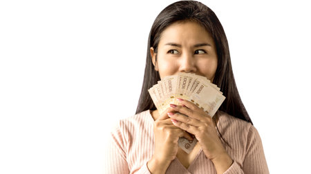 happy Asian woman smiling hand holding money standing isolated on white background plan to shoppingの写真素材
