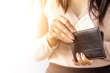 woman hand taking money from black purse for payment ,woman spending moneyの写真素材