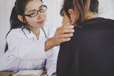Asian female doctor comforting depressed patient at a hospital after the examinationの写真素材
