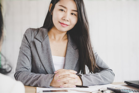 beautiful Asian business woman manager sitting in a meeting room listening to the team presenting their projectの写真素材