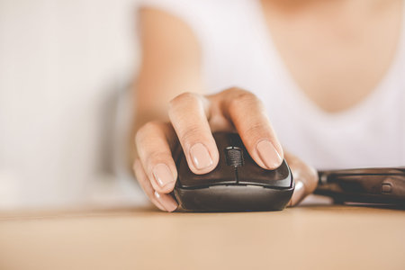 woman hand using mouse working on computer laptop in officeの写真素材
