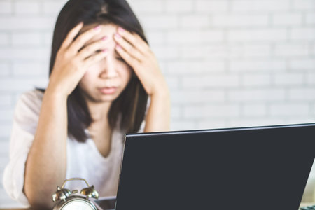 blur background of Asian business woman having eyestrain from computer screenの写真素材