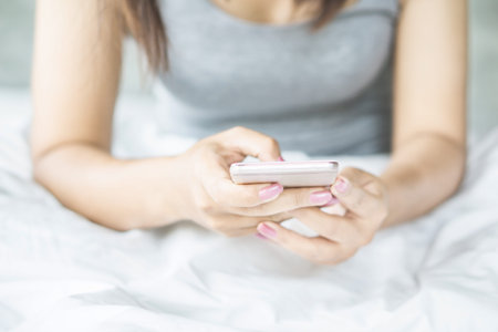 woman hand using smart phone on bed in the morning ,social addict concept