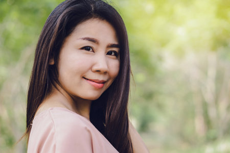 beautiful Asian woman smiling to the camera with nature outdoorsの写真素材
