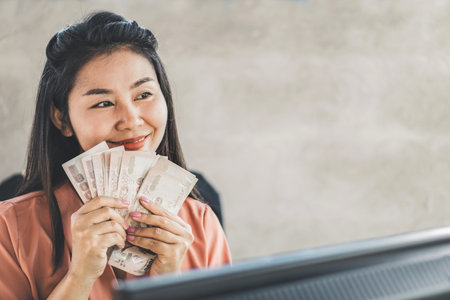 happy Asian business woman hand holding banknotes , successful with make money online concept