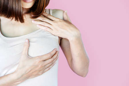 woman self breast cancer examination isolated on pink backgroundの写真素材
