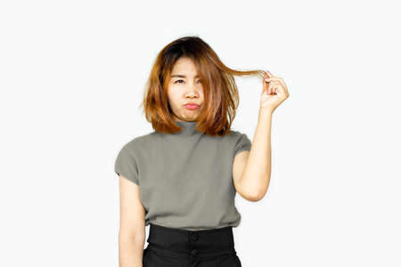 stress Asian woman having problem with damaged, thin, and dull hair caused by color dyesの写真素材