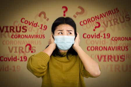depressed Asian woman with protective mask scared of covid-19 virus having panic and worry to get...