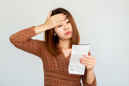 stressed Asian woman shocked with number on electricity bill ,invoice having problem with paymentの写真素材