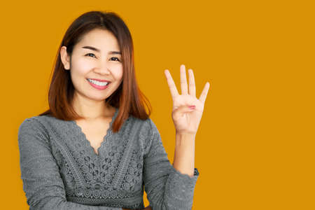 happy Asian making hand gesture showing her fingers age 40s year old with confident faceの写真素材