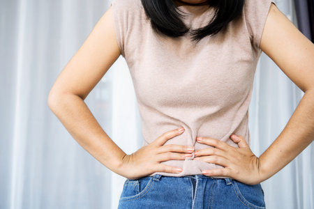 woman hand holding stomach ache having problem with abdominal painの写真素材