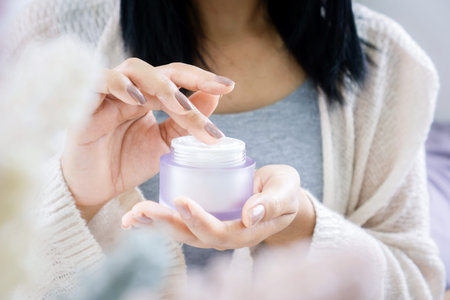 closeup woman hand applying cream ,taking moisturizer for skin hand ,face