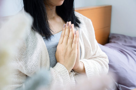 closeup Asian woman hand praying ,meditating in bedの写真素材