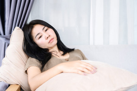 bored Asian woman sitting lonely with sad face having problem with depressionの写真素材