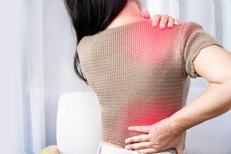 woman suffering from shoulder pain or upper back spreading to the lower backの写真素材