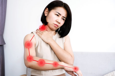 Asian woman suffering from nerve and muscle pain in neck and shoulder radiating down arm, Cervical Radiculopathy conceptの写真素材