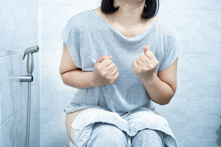 woman have problem with chronic constipation, bowel movement is painful sitting in toilet;の写真素材