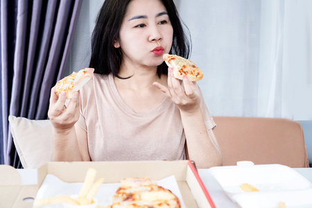 fast food addiction with unhealthy Asian woman overeating pizza, Binge eating disorder conceptの写真素材