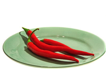 Three hot chilli peppers on a dish