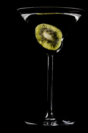 Kiwi in a glass of cocktail isolated on the blackの写真素材