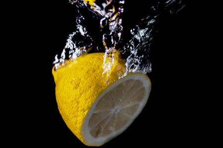 Sliced lemon in the water on black backgroundの写真素材