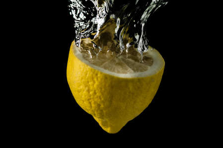 Sliced lemon in the water on black backgroundの写真素材