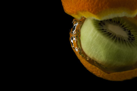 Kiwi fruit and orange in water on a black backgroundの写真素材