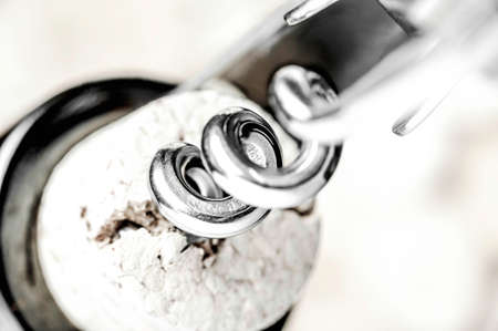 Corkscrew opening a wine bottle closeupの写真素材