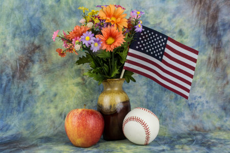assortyed flowers with an base ball and apple.の写真素材