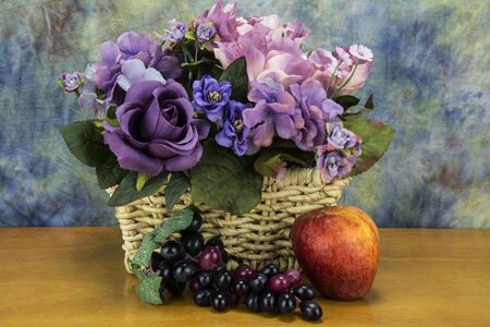 red apple with grapes and assorted flowersの写真素材
