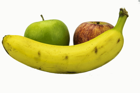 two apples with a banana in the fore groundの写真素材