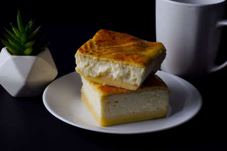 tworicotta cheese squres stack on each other against a black backgroundの写真素材