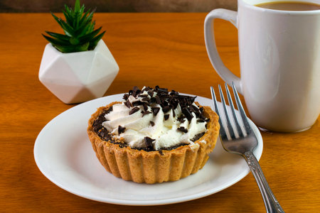 chocolate mini tart top with frosting chocolate sprinkes.