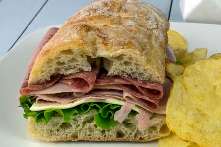 ham and salami with cheese and lettuce between ciabatta breadの写真素材