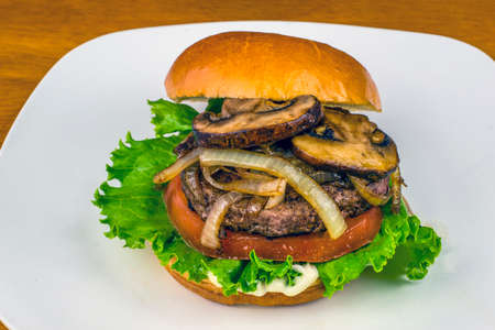 sauteed onions and mushrooms  on top of a hamburgerの写真素材