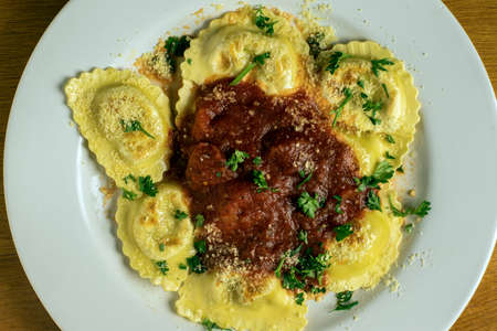 sausage ravioli served with pasta sauce parsley and parmesan cheeseの写真素材