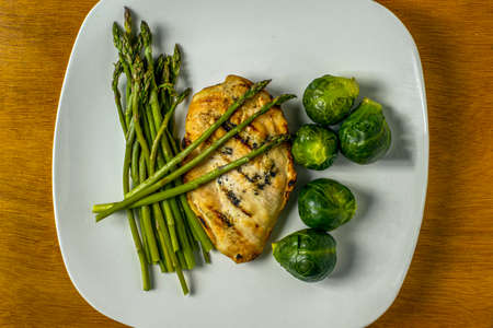 chicken cutlet served  asparagus and brussel sproutsの写真素材
