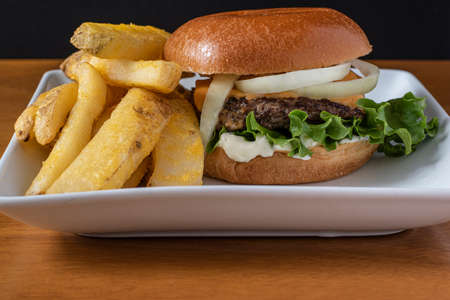 cheese burger top with  onions  on brioche bun and served with steak friesの写真素材