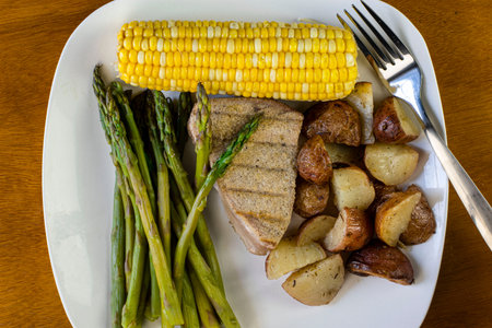 tuna  steak served with asparagus and corn