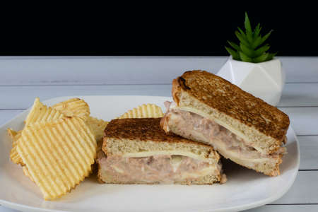 stacked tuna melt  served with potato chipsの写真素材