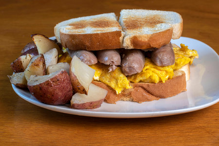 scranble egg top with sausage  served with red roasted potatoesの写真素材